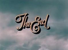 the end sign in front of a cloudy sky