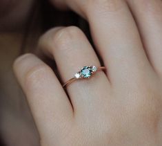 a woman's hand with a ring on it and an emerald stone in the middle