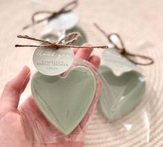 two heart shaped soaps tied with twine on top of each other in front of a glass plate