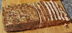 sliced meatloaf sitting on top of a wooden cutting board