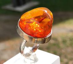 Handcrafted l Orange Amber Ring 11,7 Grams in  Sterling Silver. Unique and fashionable ring from Czech Republic. It is made of genuine orange baltic amber with the highest level of quality  silver. It is very elegant jewelry. It is adjustable and suits to everyone. Our all products are made with passion and our customers in mind. Unique Orange Ring Jewelry, Orange Hallmarked Ring As Gift, Modern Orange Rings For Gifts, Modern Orange Rings For Gift, Modern Orange Rings As Gifts, Handmade Orange Rings For Gifts, Handmade Orange Rings As Gift, Sterling Silver Orange Ring With Polished Finish, Orange Sterling Silver Ring With Polished Finish