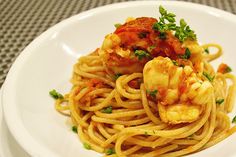 a white plate topped with pasta and shrimp