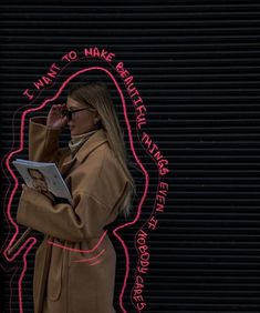 a woman standing in front of a neon sign