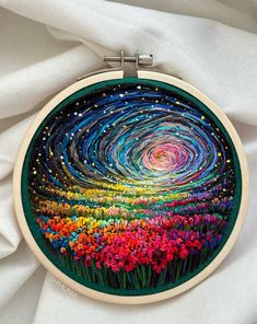 an embroidery project with flowers and stars in the sky