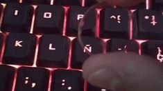 a person is typing on a keyboard with red light coming from the keypads