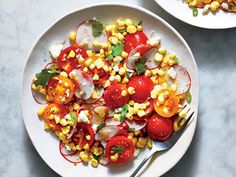 two white plates filled with corn and tomatoes