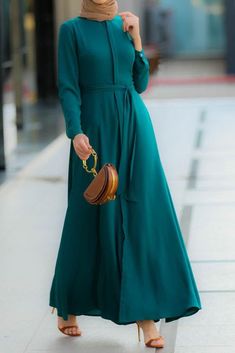 Introducing the Emerald Shirt Dress from Annah Hariri - a stunning and unique dress that is perfect for any occasion. Made from a lightweight polyester blend fabric, this dress is not lined for added comfort and breathability. The dress features buttons running all the way down the front, a detachable belt, and sleeves that are designed to be friendly for performing ablutions, making it perfect for women. It also has hidden buttons, making it breastfeeding-friendly. It can be easily cared for by Be Friendly, Abaya Design, Turkish Dress, Modest Maxi Dress, Muslimah Outfit, Hijab Designs, Kaftan Abaya, Modest Maxi, Islamic Dress