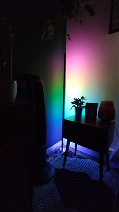 a dark room with a table and potted plant next to the wall in front of it