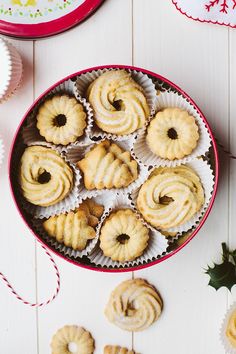 a bowl filled with pastries on top of a white wooden table next to christmas decorations