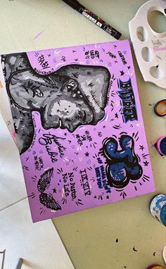 a purple poster with an elephant on it next to some paintbrushes and other crafting supplies