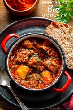 a bowl of stew with bread and parsley on the side, ready to be eaten