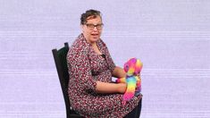 a woman sitting in a chair holding a stuffed animal