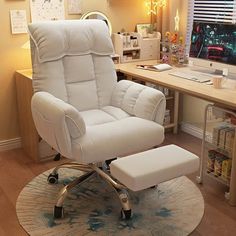 a white recliner chair sitting in front of a desk with a footstool