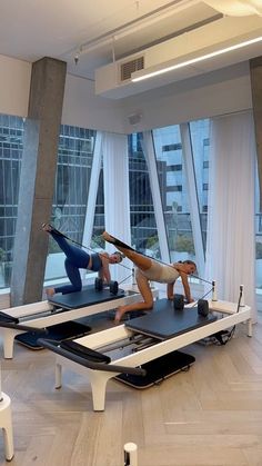 two people are doing pivots on the floor in front of large glass windows