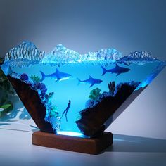 a bowl that has some sharks in it on top of a wooden stand with water