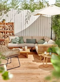 an outdoor living room with wooden furniture and umbrella