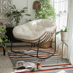 a white chair sitting on top of a rug next to a window