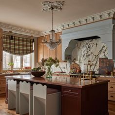 a large kitchen with marble counter tops and wooden cabinets, along with an island in the middle