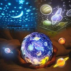 a person holding a glowing ball in their hand with planets and stars on the ceiling