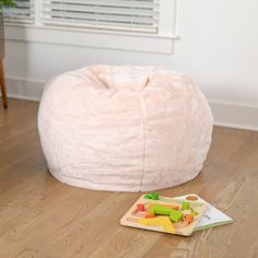 a pink bean bag sitting on top of a wooden floor