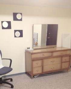 an office chair sits in front of a dresser and mirror