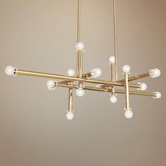 a brass chandelier with white glass balls hanging from it's center bar