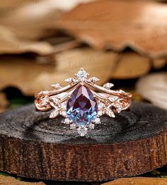 an engagement ring with a blue topazte surrounded by diamonds on a piece of wood