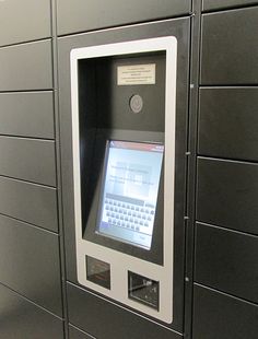 an atm machine in front of a gray wall