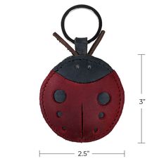 a red ladybug keychain with two black spots on the front and back