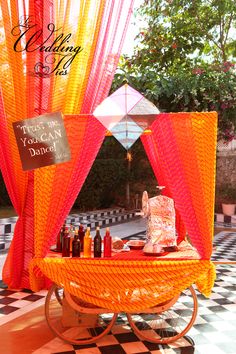 an orange and red cart with bottles on it