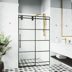 a bathroom with black and white checkered flooring, gold trimming on the shower