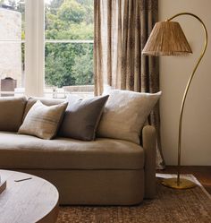 a living room filled with furniture and a lamp on top of a wooden coffee table