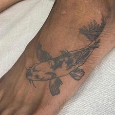 a person's foot with a fish tattoo on it