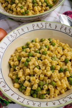 two bowls filled with pasta and peas on top of a table