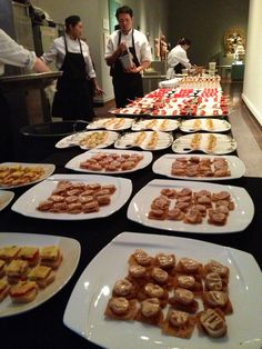 many plates of food on a table with people in the background