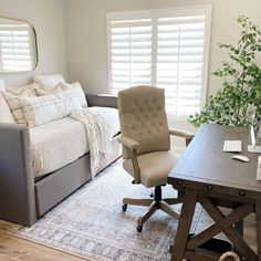 a living room with a couch, chair and desk in it's center area