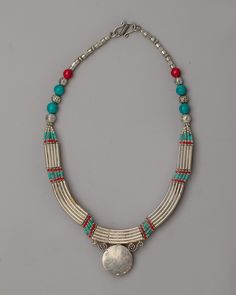 Tibetan Jewelry Necklace About our locket Embark on a journey to Tibet's mystical landscapes with our Tibetan Jewelry Necklace, a treasure crafted with care and precision. This necklace, handcrafted on a foundation of white metal and decorated with the bright shimmer of silver plating, exemplifies Tibetan artistry.This piece, embellished with brilliant imitation coral and turquoise stones, conveys a story about historical traditions and cultural riches. The vibrant coral colors and tranquil blues of turquoise give the necklace a compelling vitality symbolic of the Himalayas' sacred landscapes. This necklace, secured with an S-hook closure, is both stylish and easy to wear, making it a versatile and captivating addition to any jewelry collection. Wear this Tibetan Jewelry Necklace to embody Mystical Landscapes, Coral Colors, Tranquil Blue, Rituals Set, Treasure Crafts, Tibetan Jewelry, Green Tara, Wheel Of Life, Spiritual Meaning