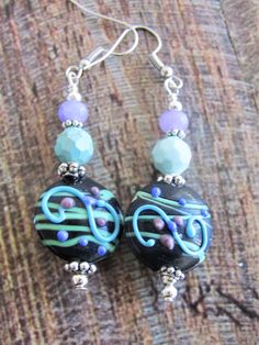 the earrings are decorated with blue and green beads