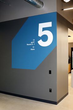 an office lobby with a large blue and white sign on the wall that says 5