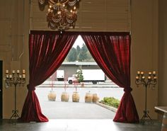 an open doorway with red curtains and chandelier