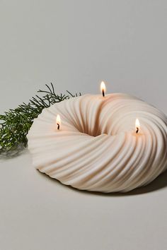 two candles sitting on top of a white object