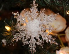 a snowflake ornament hanging from a christmas tree