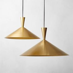 two brass colored pendant lights hanging from the ceiling, one with an upside down light