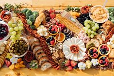 a wooden table topped with lots of different types of foods and desserts next to each other