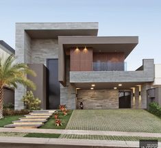 a modern house with grass and palm trees