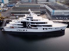 a large white and black boat in the water next to some buildings with cranes on it