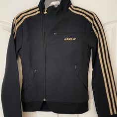 New Adidas Asymmetrical Women’s Jacket In Black With Gold Metallic Stripes. Trefoil Embroidered In Gold Metallic. 2 Zippered Pockets. Size: Xs L: 22.5. Chest: 15” Shoulder: 4.5” Sleeve: 24” Shell: 94% Nylon 6% Spandex Lining: 100% Polyester Fitted Adidas Winter Track Jacket, Fitted Adidas Track Jacket For Winter, Adidas Fitted Hooded Outerwear, Adidas Fitted Long Sleeve Outerwear, Fitted Long Sleeve Adidas Outerwear, Adidas Fitted Outerwear For Fall, Gold Adidas, Adidas Jackets, Utility Jacket