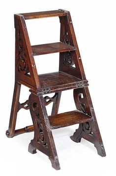 an old wooden step stool with carvings on the bottom and lower legs, against a white background