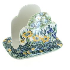 a heart shaped dish with flowers and leaves painted on the side, sitting in front of a white background