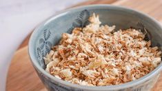 a blue bowl filled with food on top of a wooden table